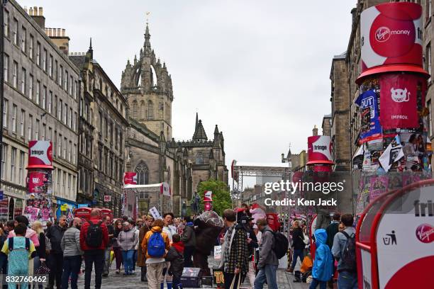 Fringe-goers and performers mingle on the Royal Mile during the Edinburgh Festival Fringe with St Giles' Cathedral in the background, on August 16,...