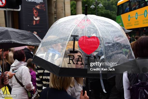 People on Princes Street brave the rain under umbrellas during the Edinburgh Festival Fringe, on August 16, 2017 in Edinburgh, Scotland. The Fringe...