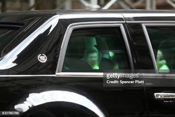 President Donald Trump waves from his motorcade vehicle after departing Trump Tower on August 16, 2017 in New York City. Trump is traveling to...