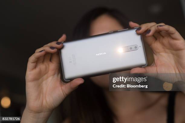 Worker takes a photo using the flash on the Nokia 8 smartphone, designed by HMD Global Oy, ahead of its official unveiling in London, U.K., on...