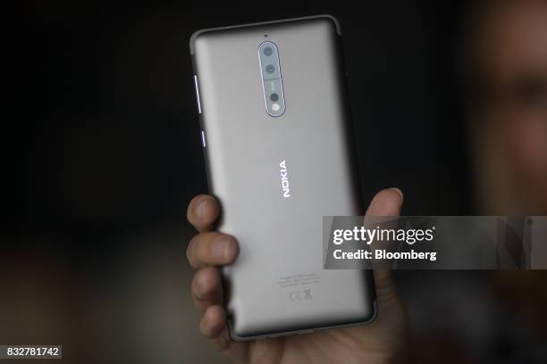Worker holds the Nokia 8 smartphone, designed by HMD Global Oy, ahead of its official unveiling in London, U.K., on Tuesday, Aug. 15, 2017. The phone...