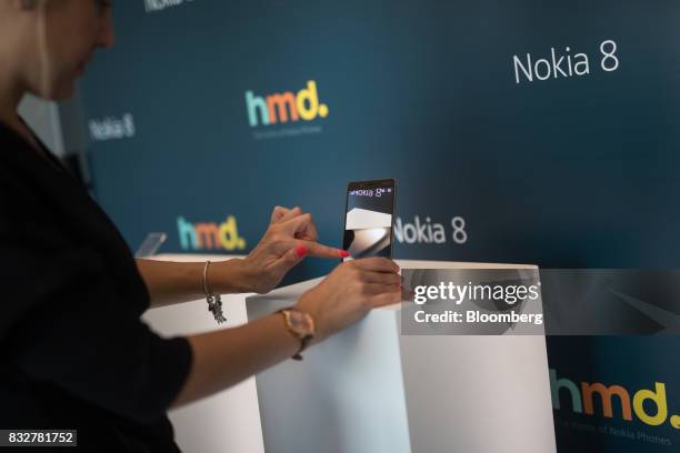 Worker demonstrates the Nokia 8 smartphone, designed by HMD Global Oy, ahead of its official unveiling in London, U.K., on Tuesday, Aug. 15, 2017....