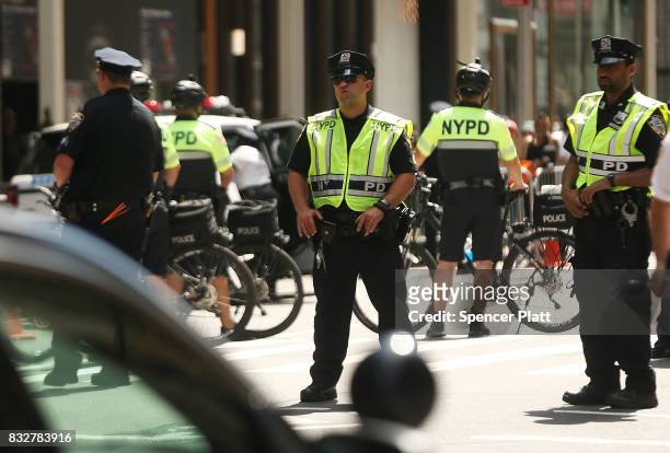 Police stand in front of protesters as President Donald Trump's motorcade departs Trump Tower on August 16, 2017 in New York City. Trump is traveling...