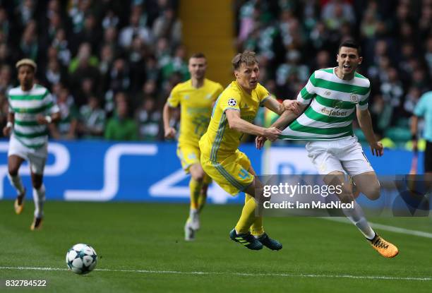Evgeni Postnikov of FC Astana vies with Tomas Rogic of Celtic during the UEFA Champions League Qualifying Play-Offs Round First Leg match between...