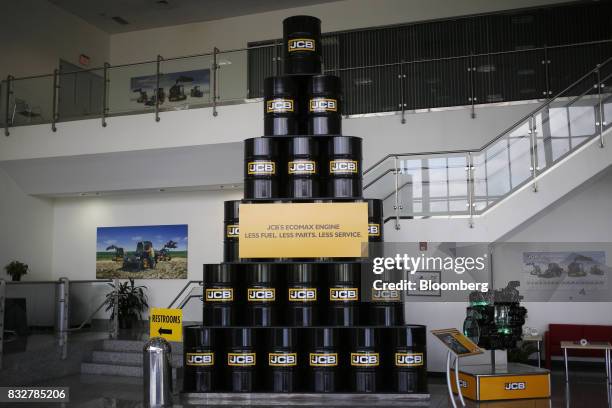 Decorative oil barrels sit on display in the lobby of the JC Bamford Excavators LTD. Manufacturing plant in Pooler, Georgia, U.S., on Friday, Aug....