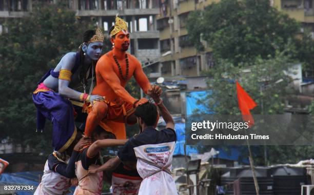 Govindas in Lord Krishna and Hanuman outfits form human pyramid to break earthen pots during Dahi Handi celebration on the occasion of Krishna...