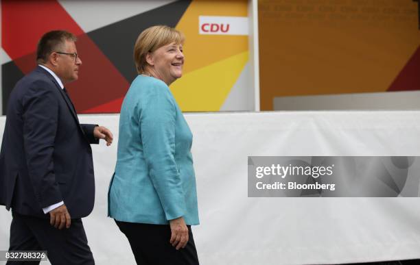 Angela Merkel, Germany's chancellor and Christian Democratic Union leader, right, smiles as she walks off stage during an election campaign stop in...