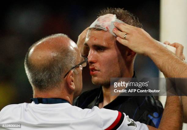 Paramedics help Nice's French defender Maxime Le Marchand injured during the UEFA Champions League Play Off first leg football match SSC Napoli vs...