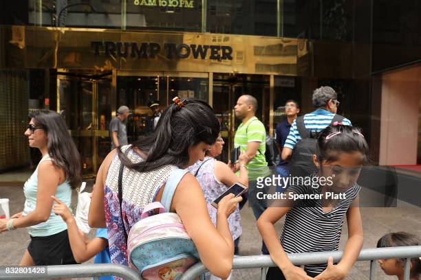 People walk outside of Trump Tower after it re-opened to the public following the departure of US President Donald Trump on August 16, 2017 in New...