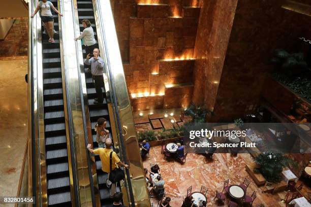 People walk through Trump Tower after it re-opened following the departure of US President Donald Trump on August 16, 2017 in New York City....