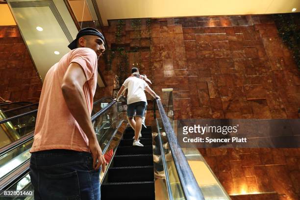 People walk through Trump Tower after it re-opened following the departure of US President Donald Trump on August 16, 2017 in New York City....