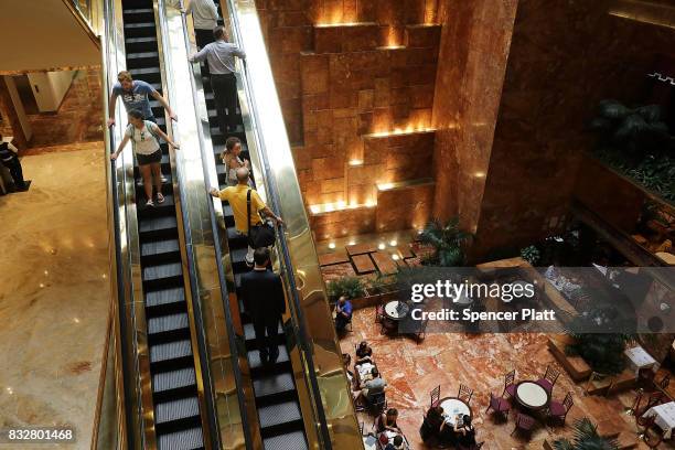 People walk through Trump Tower after it re-opened following the departure of US President Donald Trump on August 16, 2017 in New York City....