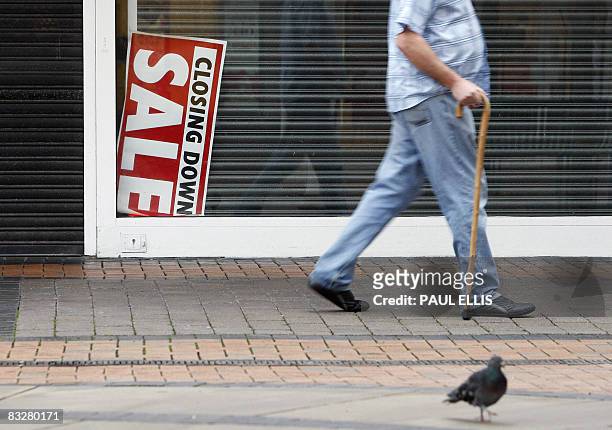 Man walks past a 'Closing Down Sale' sign in a shop window in Birkenhead in north-west England, on October 15, 2008. The next few days will be...