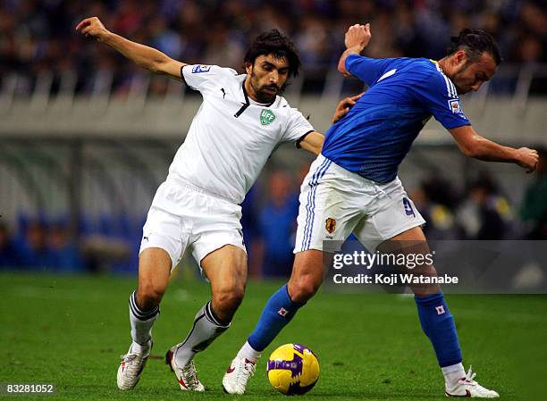 Marcus Tulio Tanaka of Japan and Azizbek Haydarov of Uzbekistan compete for the ball during the 2010 FIFA World Cup qualifier match between Japan and...