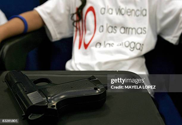 Child sits beside a fake plastic gun during a toy exchange program in Alajuela, 22 kilometers north of San Jose, on September 9, 2008. Dozens of...