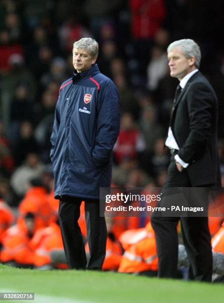 Arsenal manager Arsene Wenger stands dejected on the touchline as Blackburn Rovers manager Mark Hughes looks on