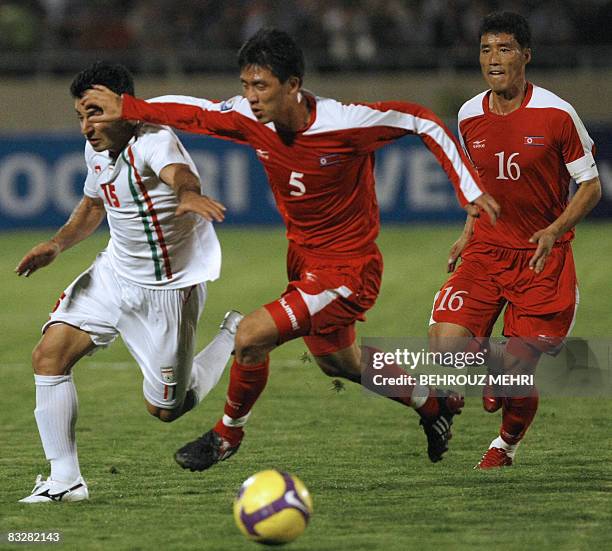 Iran's Gholamreza Rezaei competes with North Korea's Kwang Chon Ri and Song Chol Nam during their group two Asian qualifying match for the 2010 World...