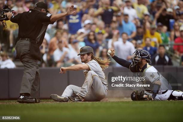 John Jaso of the Pittsburgh Pirates beats a tag at home plate by Manny Pina of the Milwaukee Brewers during the seventh inning of a game at Miller...