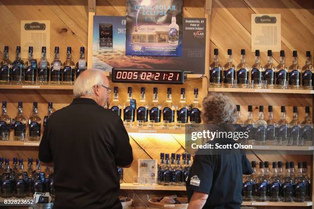 An eclipse countdown clock sit among a display of Total Eclipse Moonshine, which was distilled to commemorate the upcoming solar eclipse, at Casey...