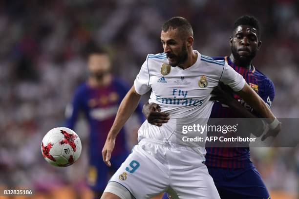 Real Madrid's French forward Karim Benzema vies with Barcelona's French defender Samuel Umtiti during the second leg of the Spanish Supercup football...