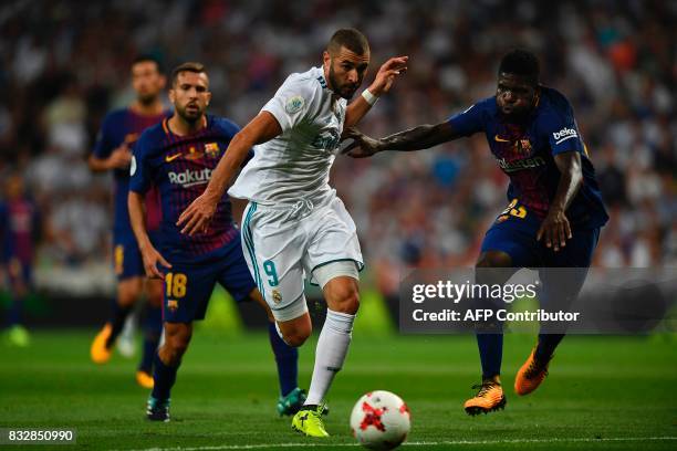 Real Madrid's French forward Karim Benzema vies with Barcelona's French defender Samuel Umtiti during the second leg of the Spanish Supercup football...