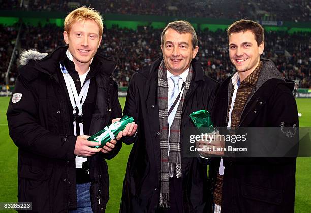 Wolfgang Niersbach of German Football Federation gives a present to table tennis players Christian Suess and Timo Boll during the FIFA 2010 World Cup...