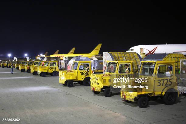 Workers wait to transport package containers at the DHL Worldwide Express hub of Cincinnati/Northern Kentucky International Airport in Hebron,...
