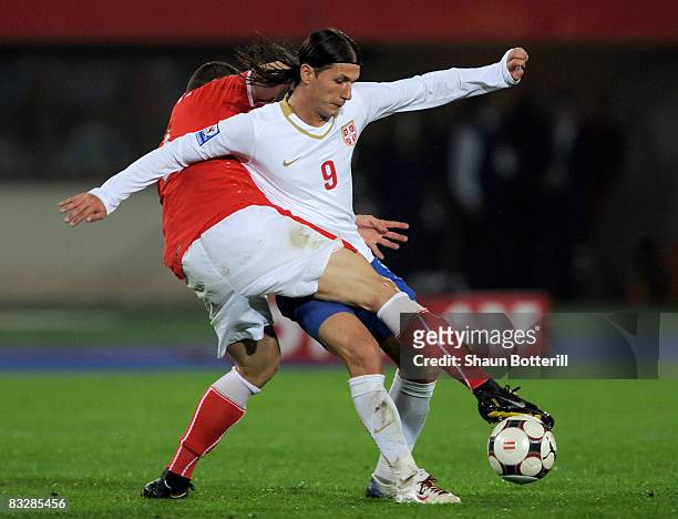 Marko Pantelic of Serbia is challenged by Emanuel Pogatetz of Austria during the FIFA 2010 World Cup Qualifying Group 7 match between Austria and...