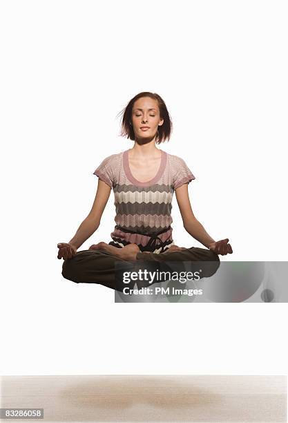 woman floating in yoga pose - lotus position stock pictures, royalty-free photos & images