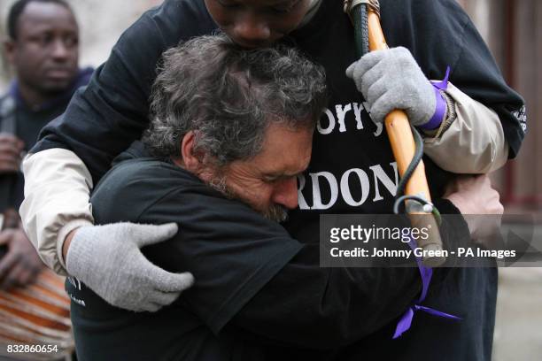 David Pott and Monette Tapa Mekomou embrace besides the Buxton Memorial in Victoria Tower Gardens, Westminster, central London, as they join a Walk...