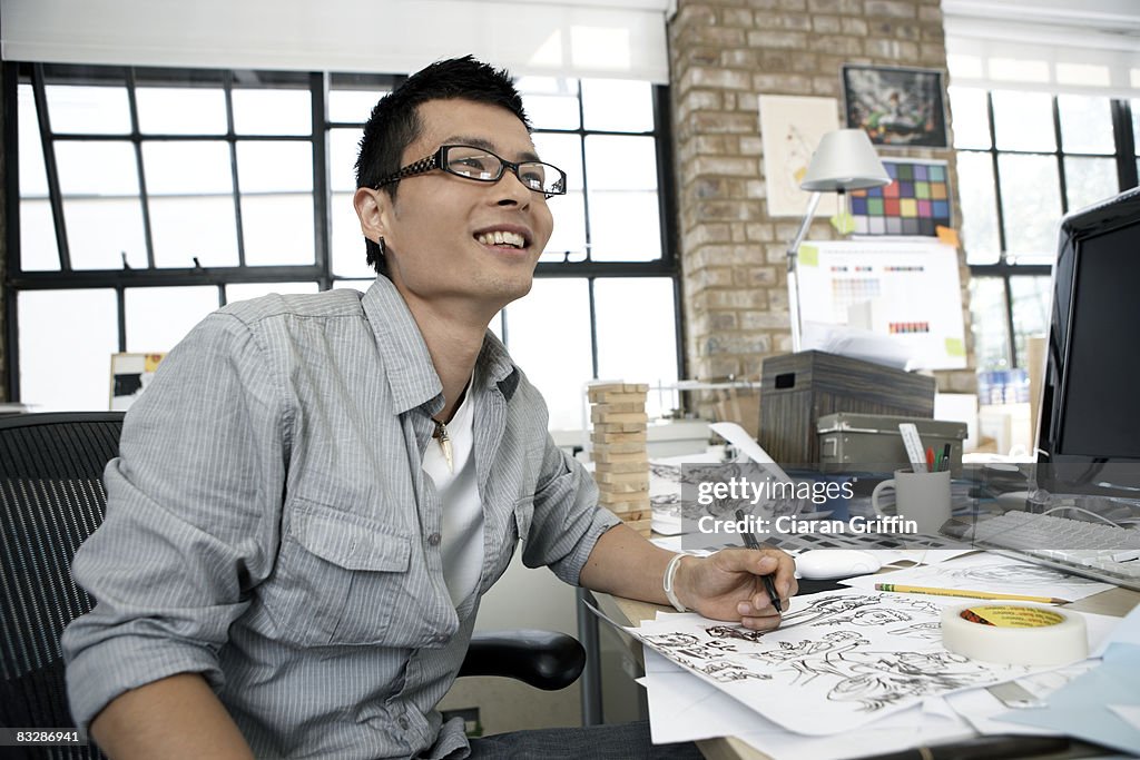 Young illustrator smiling away from the camera