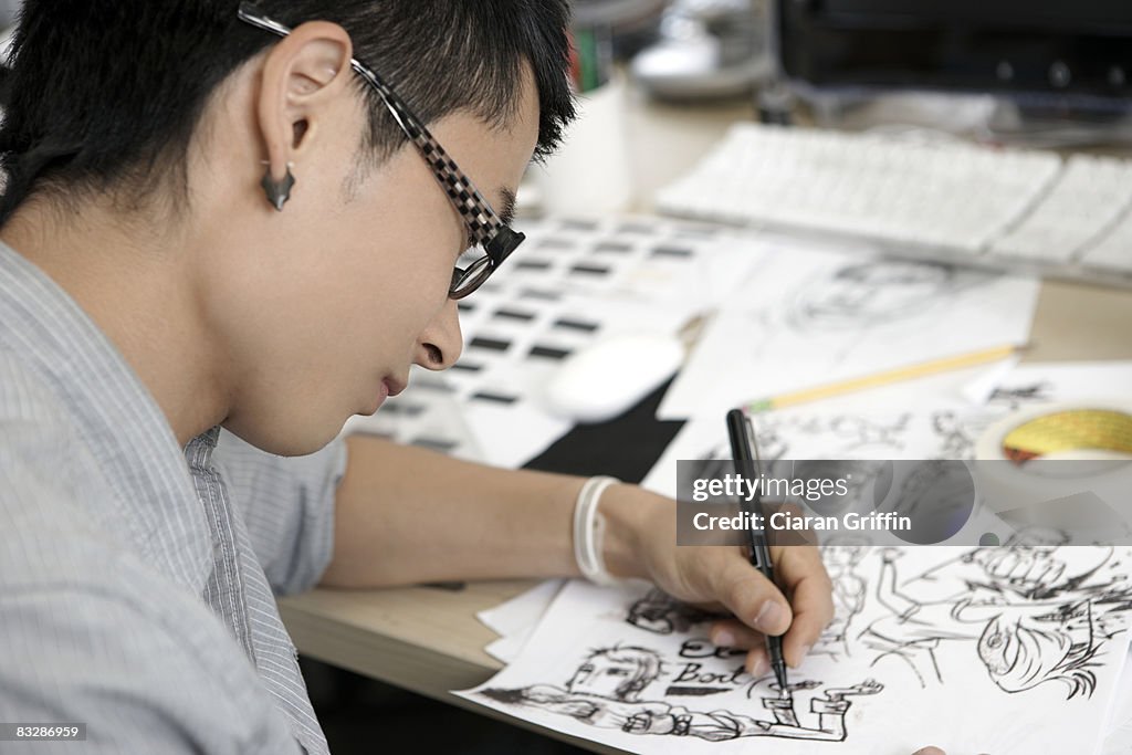 Young man illustrating comics at his desk