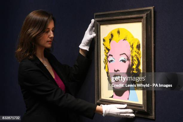 An Andy Warhol portrait of Marilyn Monroe titled Lemon Marilyn is adjusted at Christie's in London before the Christie's Post-War and Contemporary...