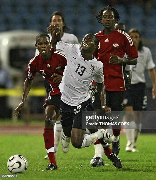 Football player midfielder Maurice Edu is tackled by Trinidad and Tobago' s defender Aklie Edwards and midfielder Keon Daniel during their FIFA World...