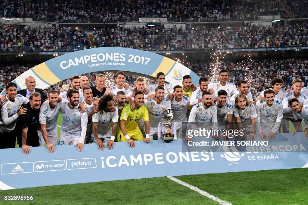 Real Madrid's defender Sergio Ramos holds the trophy as he and teammates celebrate their Supercup after winning the second leg of the Spanish...
