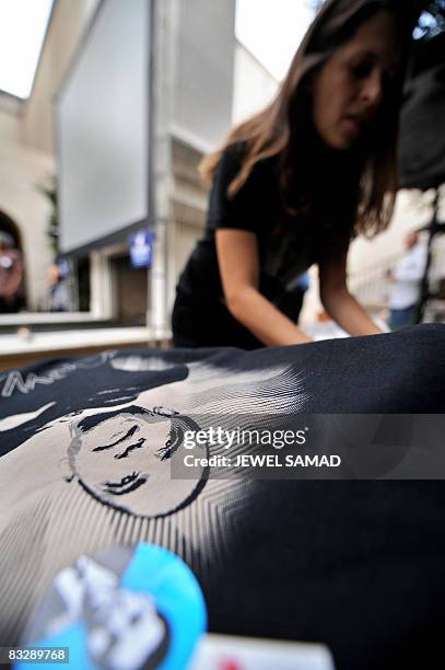 Volunteer arranges T-shirts featuring pictures of Democratic presidential candidate Barack Obama for sale to supporters who arrive to watch the...