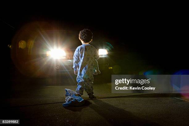 car and toddler in driveway, night - 3 men standing outside stockfoto's en -beelden