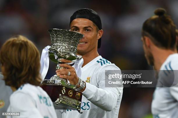 Real Madrid's Portuguese forward Cristiano Ronaldo holds up the trophy as he celebrates their Supercup after winning the second leg of the Spanish...