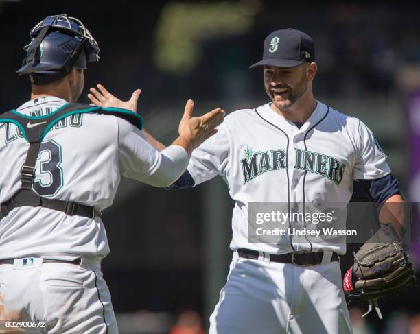 Catcher Mike Zunino of the Seattle Mariners celebrates with Marc Rzepczynski after Rzepczynski struck out Chris Davis of the Baltimore Orioles for...