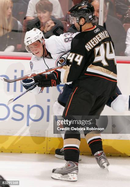 Ales Hemsky of the Edmonton Oilers is checked into the boards by Rob Niedermayer of the Anaheim Ducks during the game on October 15, 2008 at Honda...