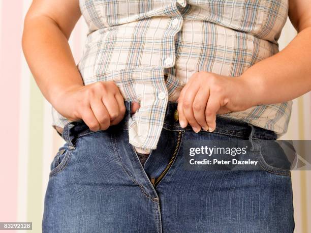 obese teenager doing up jeans - girls in tight pants stock pictures, royalty-free photos & images