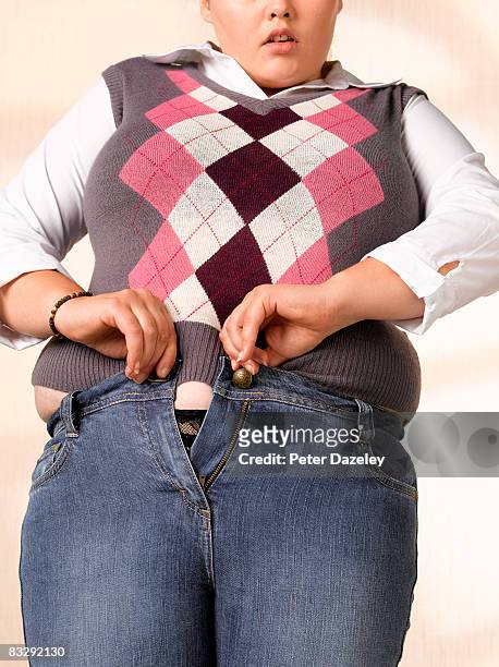 overweight teenager trying to do up jeans - fat girls stock-fotos und bilder