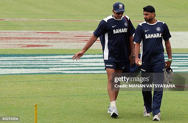 Indian cricket captain Anil Kumble gestures while talking to teammate Harbhajan Singh during a training session at The Punjab Cricket Association...