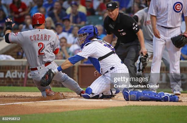 Zack Cozart of the Cincinnati Reds is tagged out at the plate by Alex Avila of the Chicago Cubs in the 1st inning at Wrigley Field on August 16, 2017...