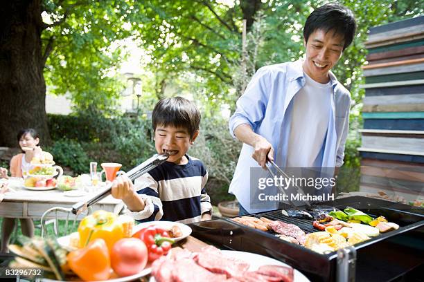 boy eats by stealth,man cooking barbecue - asian man cooking stockfoto's en -beelden