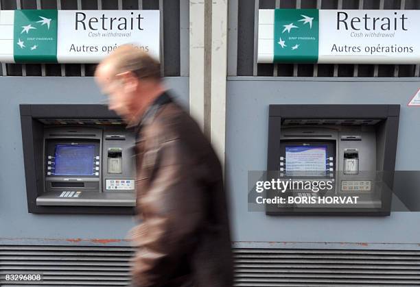 Man walks past an ATM machine of the French Bank BNP Paribas on October 16, 2008 in Paris. French stocks plunged 4.95 percent in initial trading, hit...