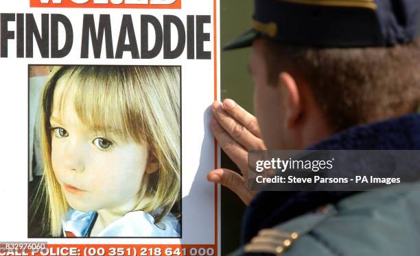 Portuguese police officer looks at a poster at the Ocean Club in Luz in the Algarve, Portugal, where Madeleine McCann went missing on Thursday...