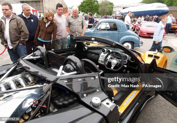 Visitors look over the 580,000 Zonda F Roadster with, in the background, the 1949 Fiat Topolino 500c, worth an estimated 130 in 1949, during the...