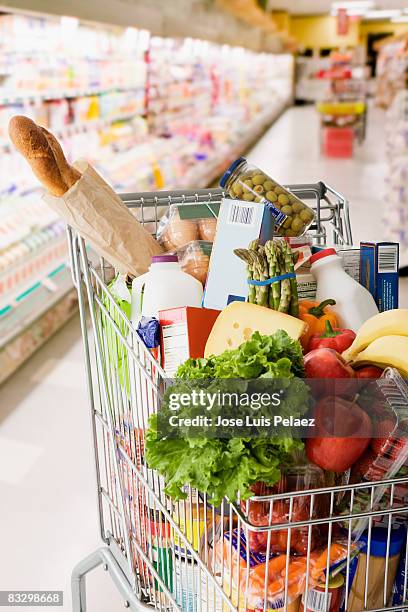 grocery cart full of groceries - caddie photos et images de collection