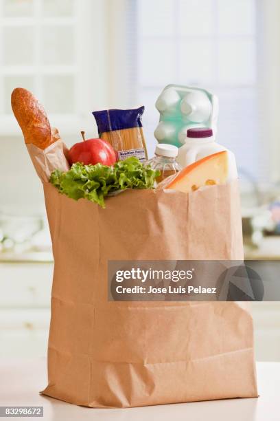 grocery bag full of groceries - einkaufstüten stock-fotos und bilder